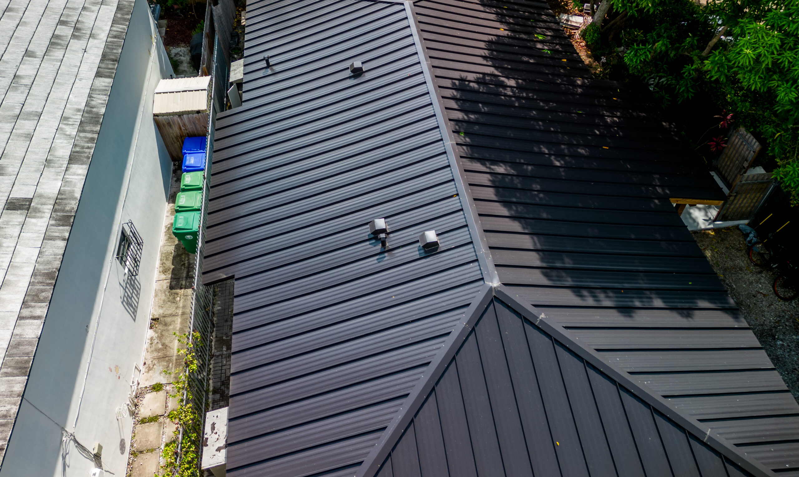 Aerial drone view of a metal roofing installation in Miami, South Florida — showing the installation phase of a residential roofing project