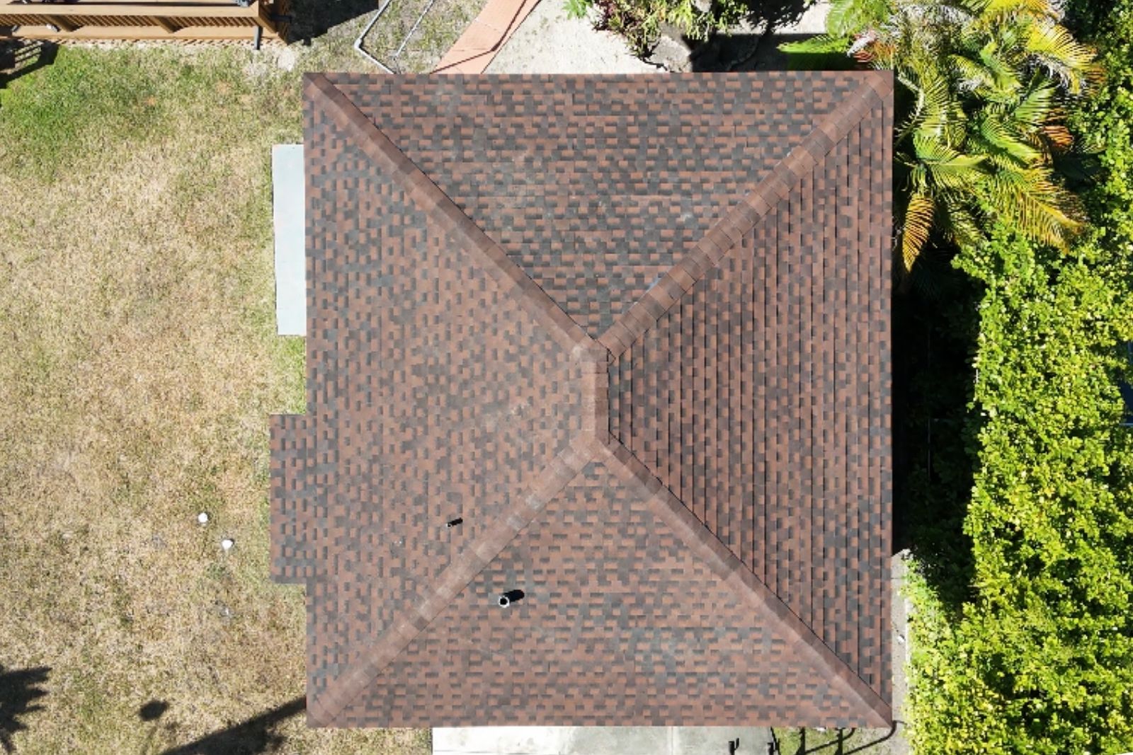 Aerial top-down view of a completed asphalt shingle roof on a South Florida home