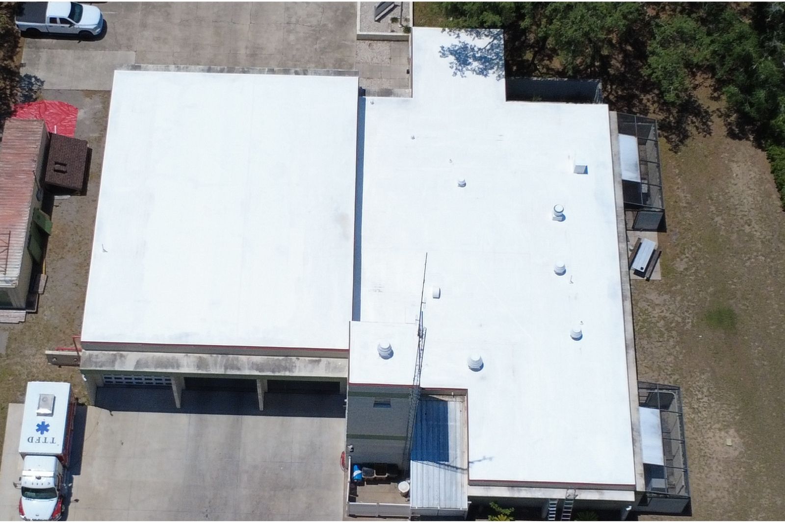Aerial view of a commercial flat roof finished with a white reflective coating.
