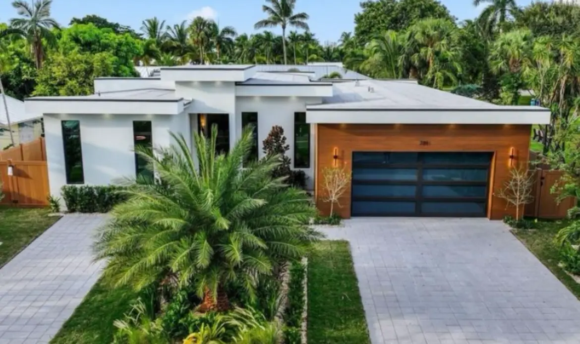 South Florida home with flat roof, white walls, and tropical landscaping
