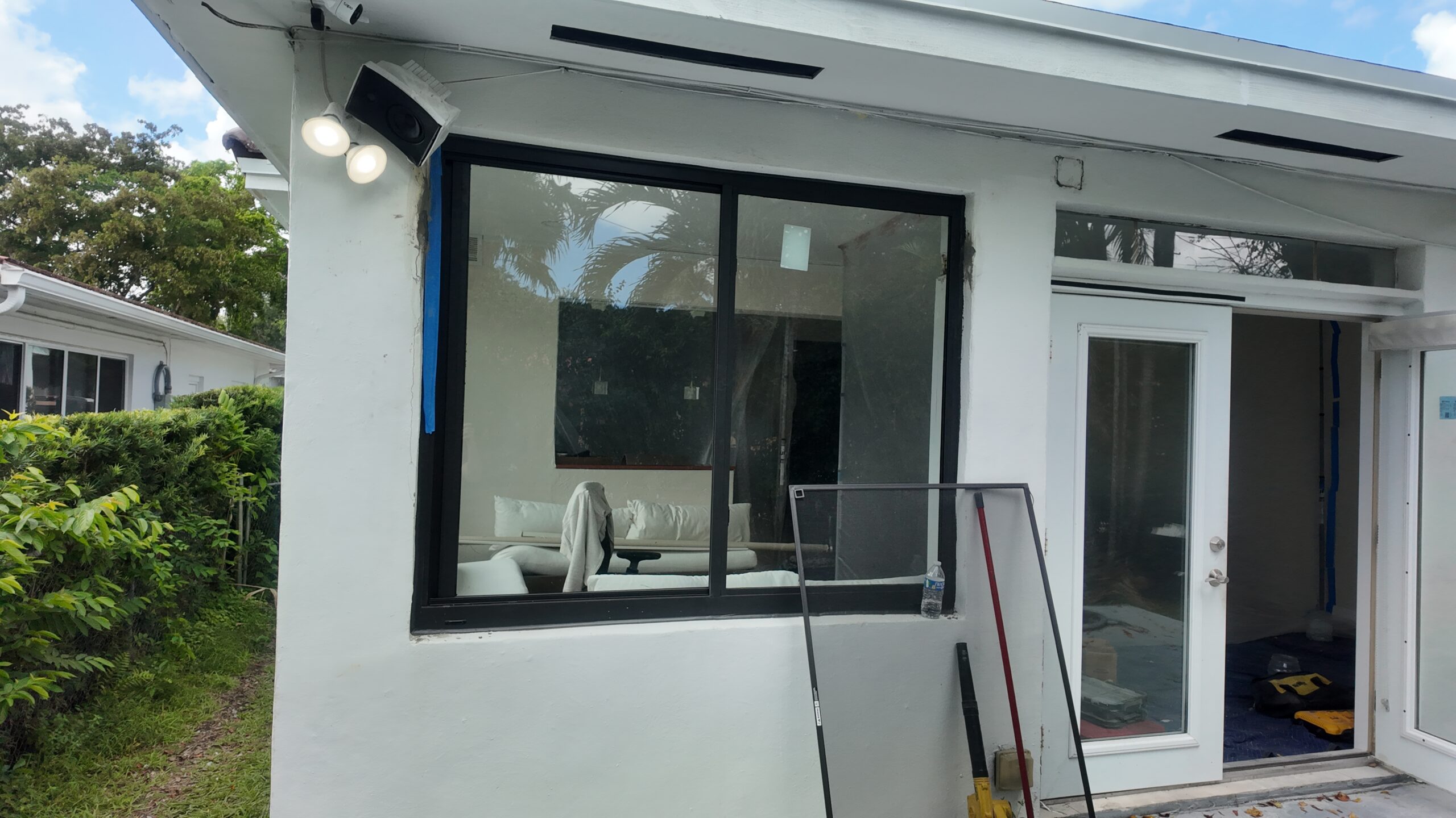 New dark-framed window during installation at the Coral Gables home